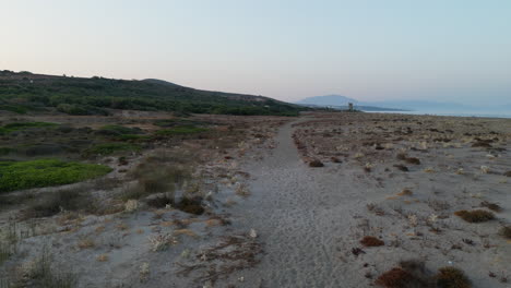 Low-level-drone-shot-travelling-above-wild-beach-in-Spain-at-sunset