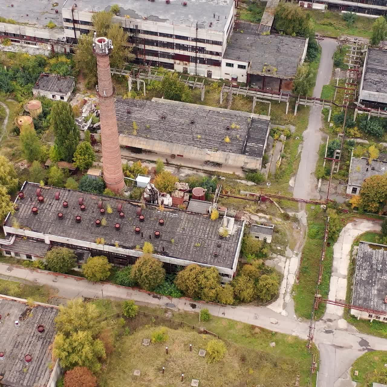Old industrial area. Abandoned buildings with old roofs. Destructive architecture of old factory. Aerial view