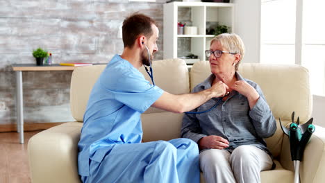 male doctor putting his stethoscope on and listening old woman heartbeat