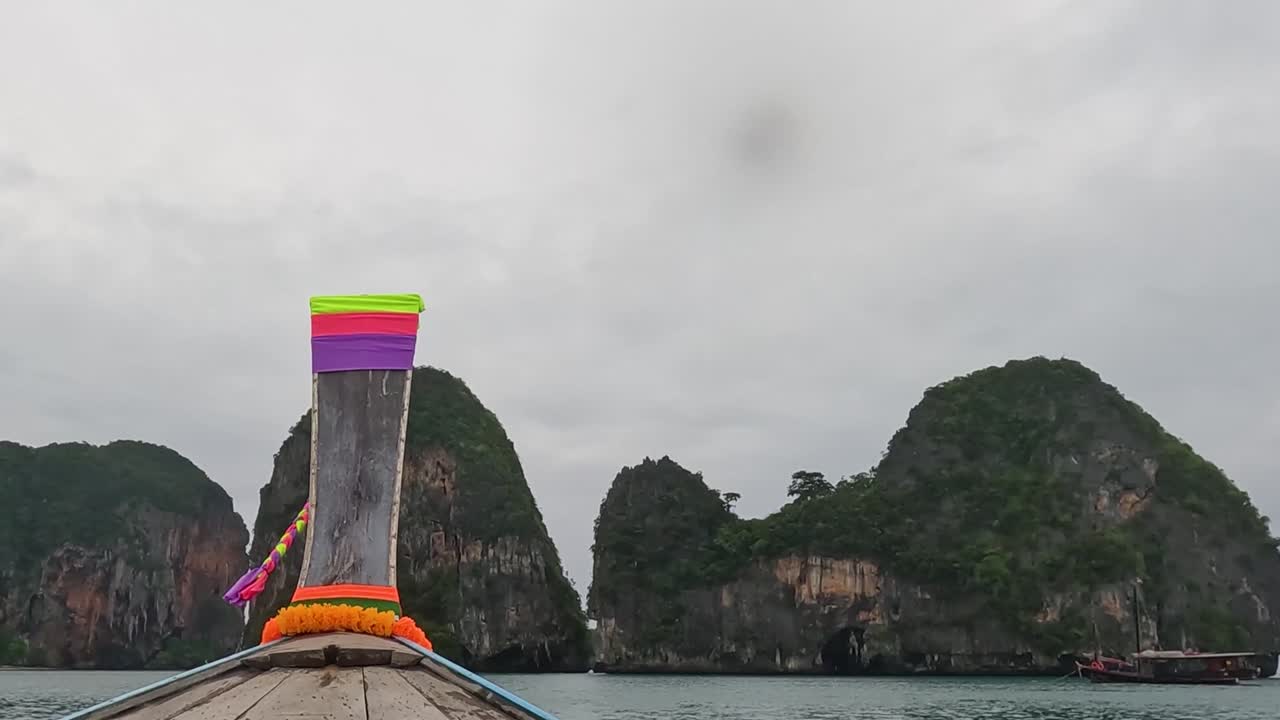 A boat journey through towering limestone formations under an overcast sky, showcasing natural beauty and tranquility.