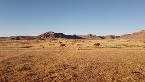 adventure across endless dunes: 4k drone shot of desert drive in namibia, africa with rooftop-tented 4x4 toyota hilux