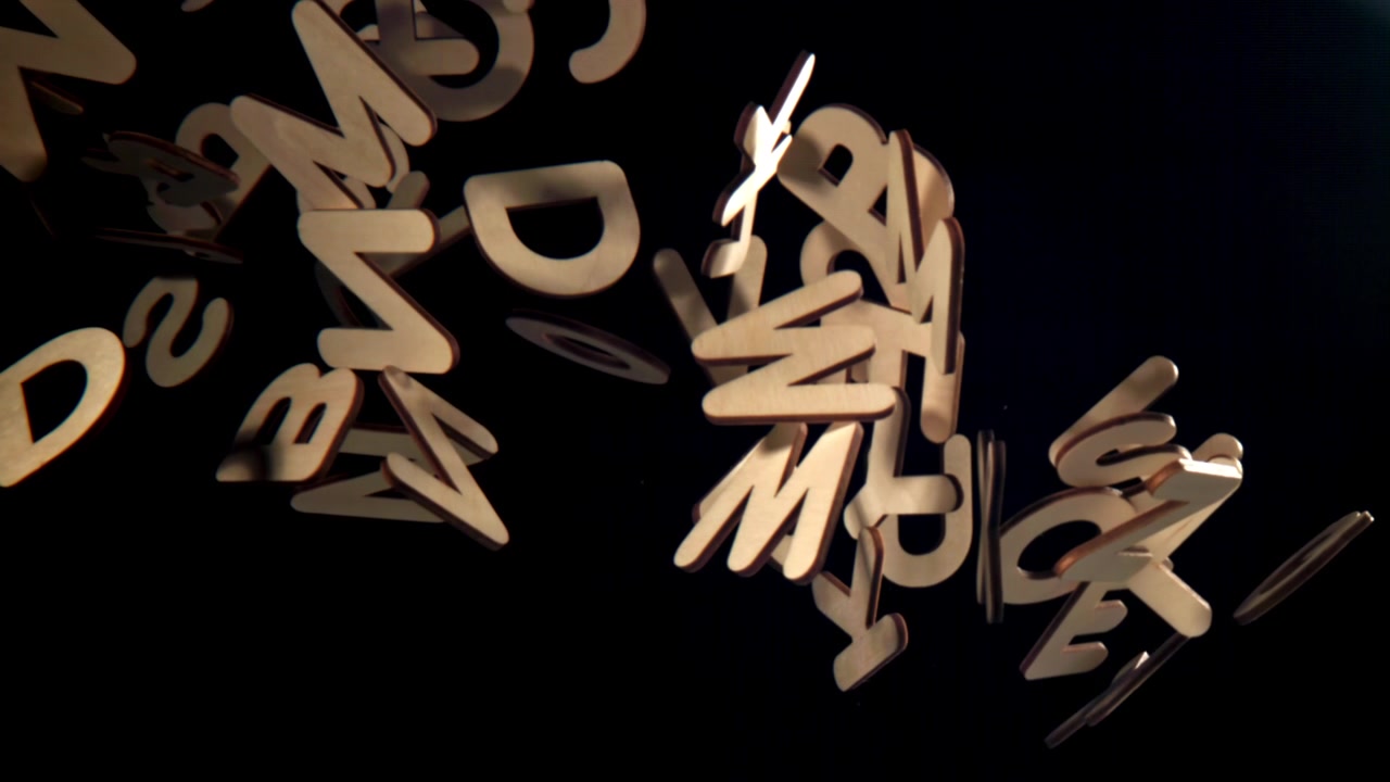 Wooden Alphabet Letters Falling in Slow Motion on Black Background