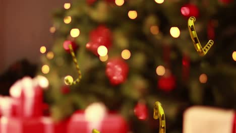 animación de las cañas de caramelo de oro de navidad cayendo sobre el fondo del árbol de navidad.