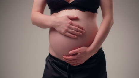 mujer en embarazo avanzado se acaricia el vientre lleno