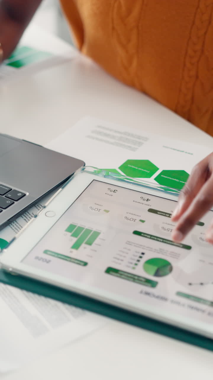 Person's Hands Analyzing Business Data on Tablet and Laptop