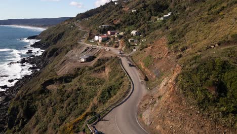 seguimiento aéreo de coches en una carretera en un acantilado cerca de la costa rocosa