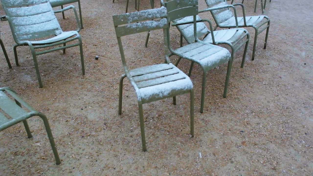 Slow-motion of snow Accumulating on Green Chairs in Luxembourg Gardens
