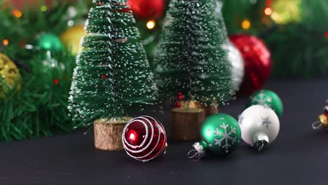 little christmas ornaments and christmas pine trees with blinking lights behind