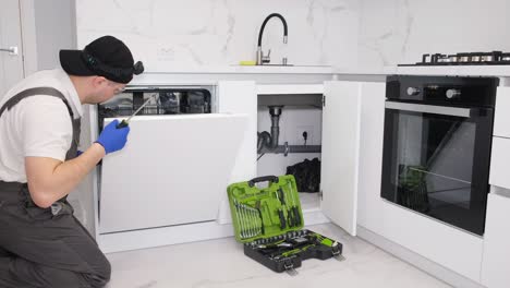 professional electrician wearing protective gloves installing ceiling light fixture connecting