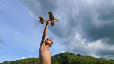 child playing with cardboard airplane