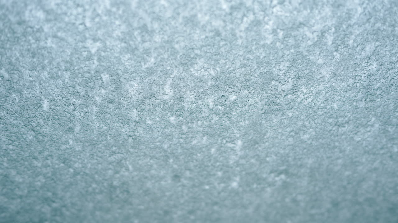 Primo piano di una superficie ghiacciata o satinata con texture fine e tenui tonalità di blu