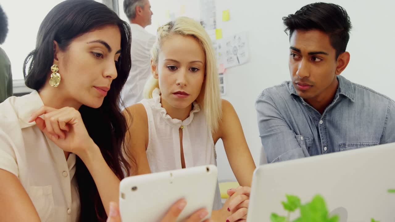 ejecutivos de negocios discutiendo sobre computadora portátil y tableta digital 4k