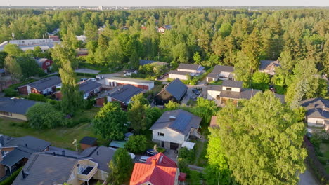 drone circling a solar powered home in middle of suburban houses, summer evening