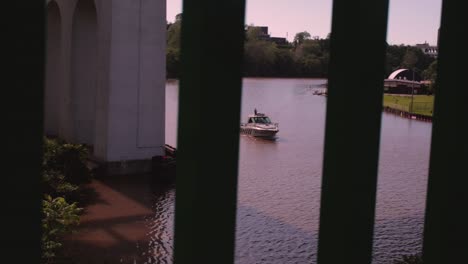 the cuyahoga river around dusk where a boat passes under a train trestle bridge