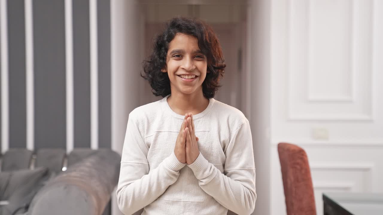 Indian teenager kid boy doing Namaste as greetings