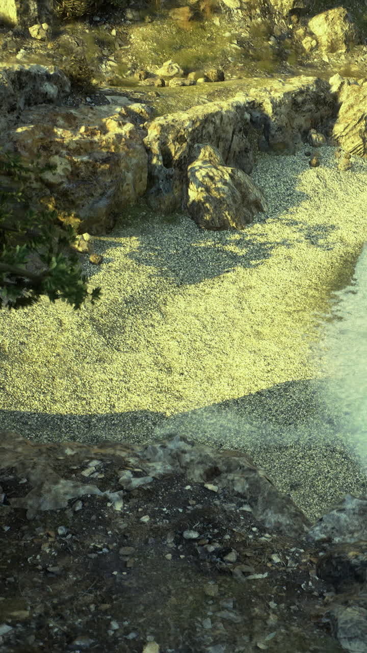 Rocce e ghiaia vicino all'acqua sotto la luce del sole in un sito naturale