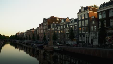 un barrio de amsterdam, países bajos, a la luz de la mañana con las casas reflejadas en el agua del canal