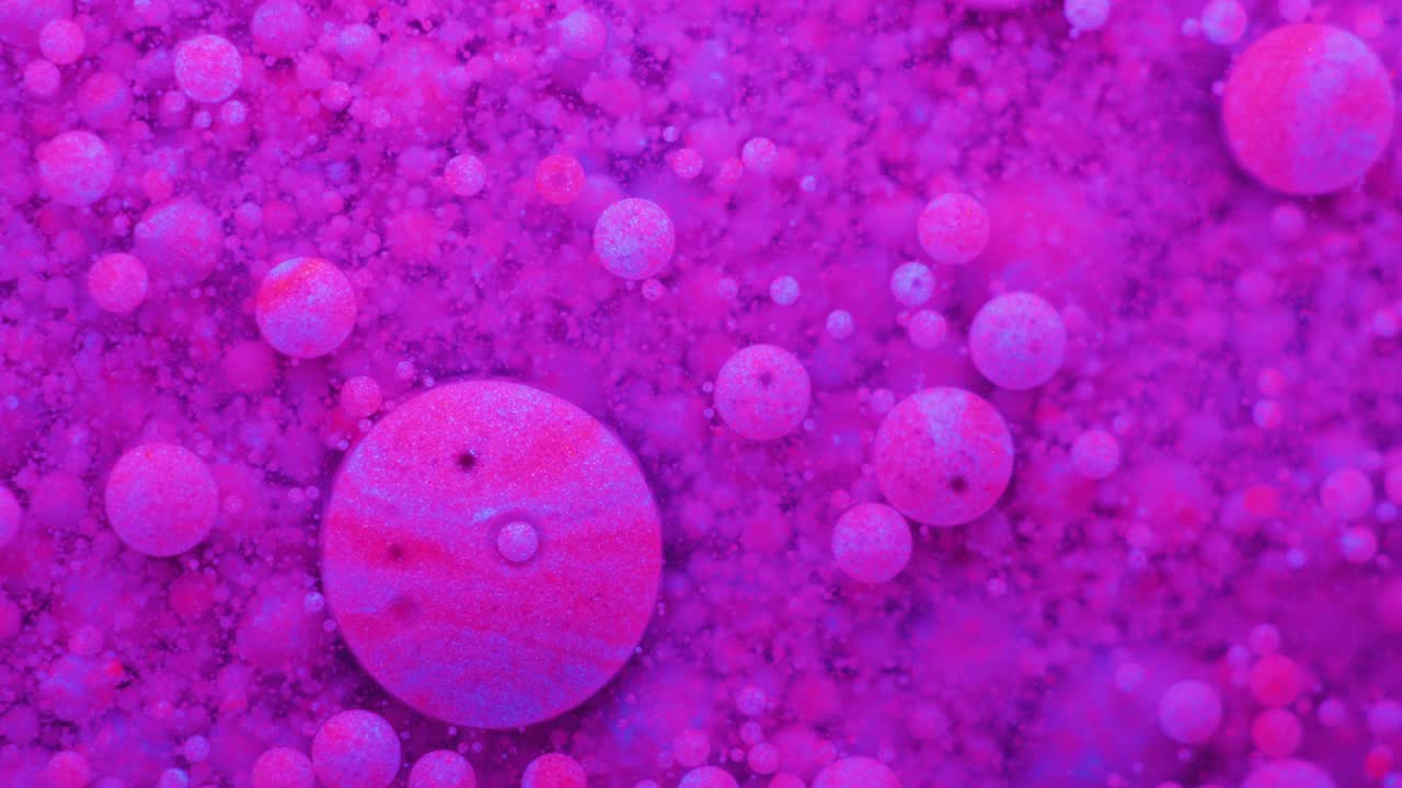 Slow Motion Bright Neon Color Bubbles Oil Beautiful Fluorescent Paint Sparkling Color Moving Multicolor Close up. Acrylic Neon Paint. Fantastic Surface. Abstract Colorful Transformation Gravitation.