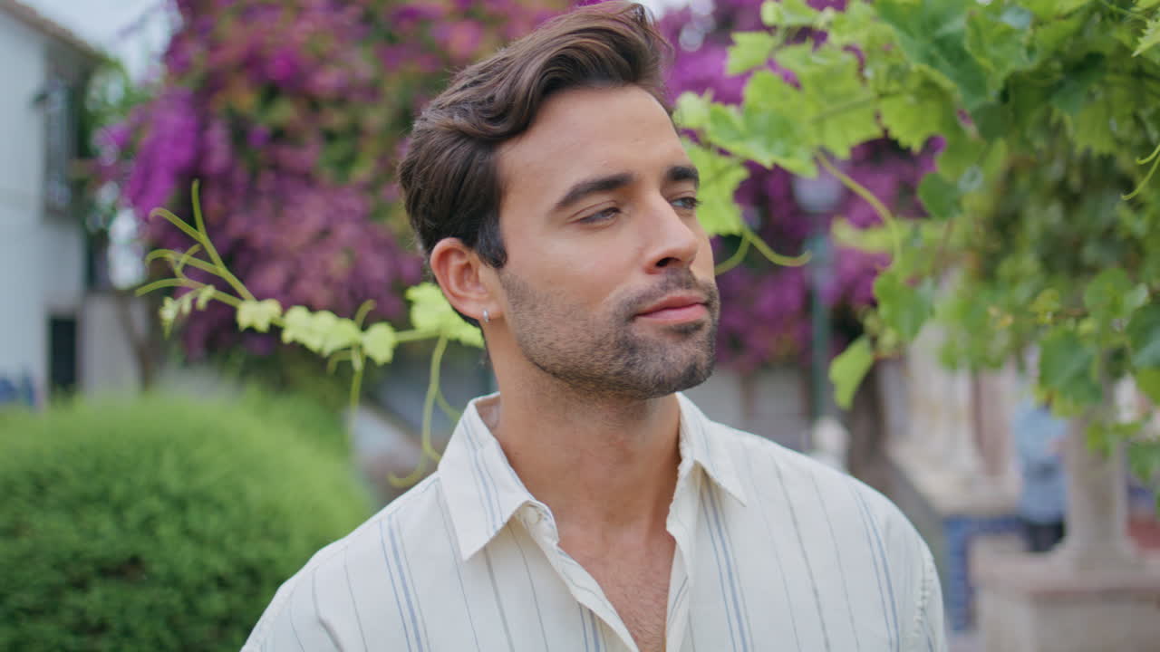 hombre de aspecto romántico a distancia cerca de un arbusto de uva. retrato macho