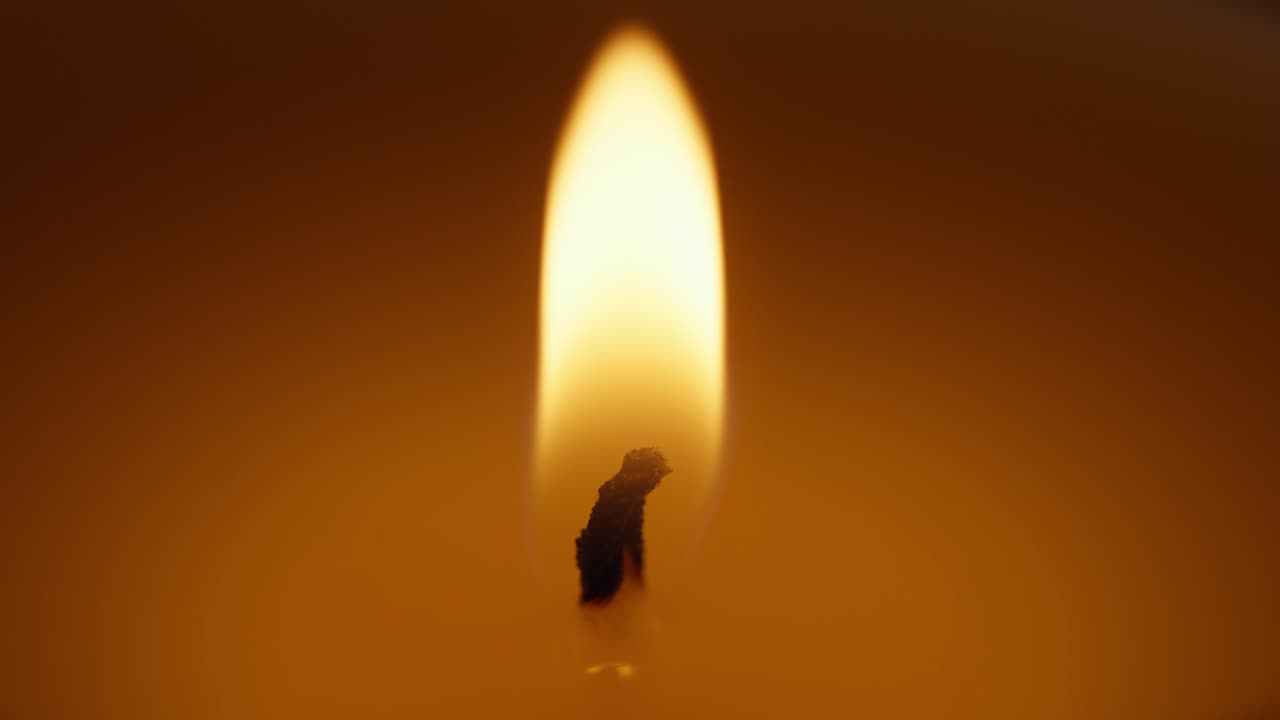 macro shot of a candles wick lit with the flame of a fire