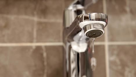 metal tap and water drop dripping, loop background close up, cinematic dof