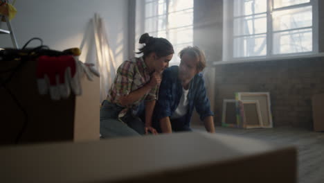 una joven pareja sentada en el fondo de la construcción. una familia discutiendo planos.