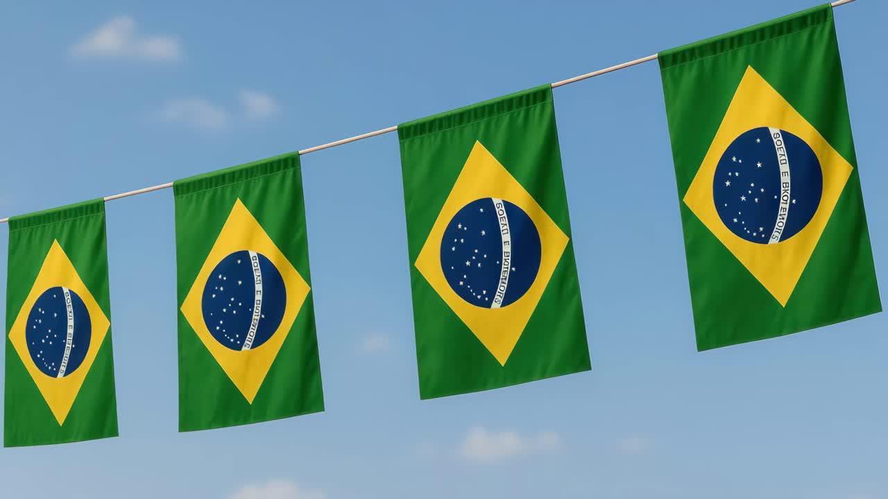 Low-angle video shot of four Brazilian flags waving against a clear blue sky, capturing a sense