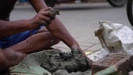 man working with clay and bricks