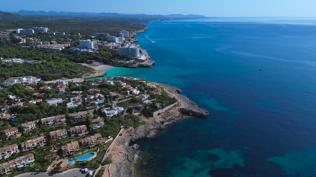 La splendida zona di Cala Murada a Maiorca. Caratterizzata da grandi complessi turistici, spiagge sabbiose affollate, calette rocciose e il vivido mare turchese del Mediterraneo in una giornata di sole