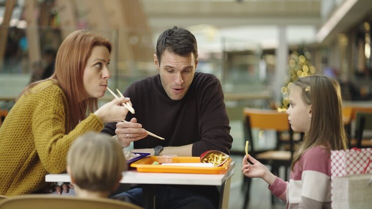 Family eating a casual meal in a mall food court during the holiday season