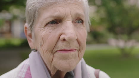 close up portrait of elderly caucasian woman serious looking pensive thoughtful in park