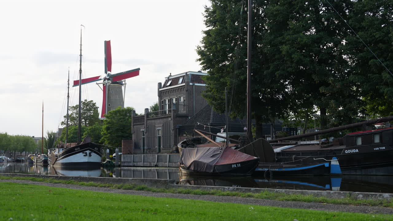 네덜란드 가우다 의 터프싱 ⁇  에 있는 상징적 인 밀가루 공장 인 molen de roode leeuw 와 오래된 배 들