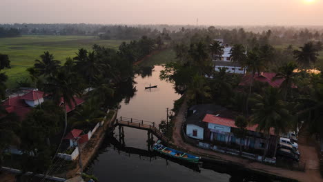 aldea a orillas del río en alleppey con exuberantes palmeras en kerala, india