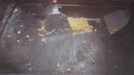 vendor grills taiwanese street food corn topped with melting cheese, creating a deliciously smoky and creamy treat at a bustling night market