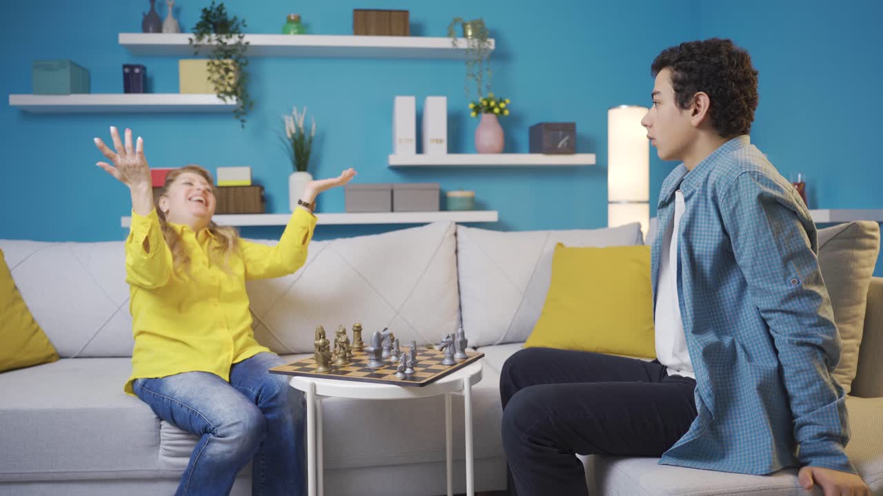 la madre y el hijo están jugando al ajedrez, el hijo está perdiendo.