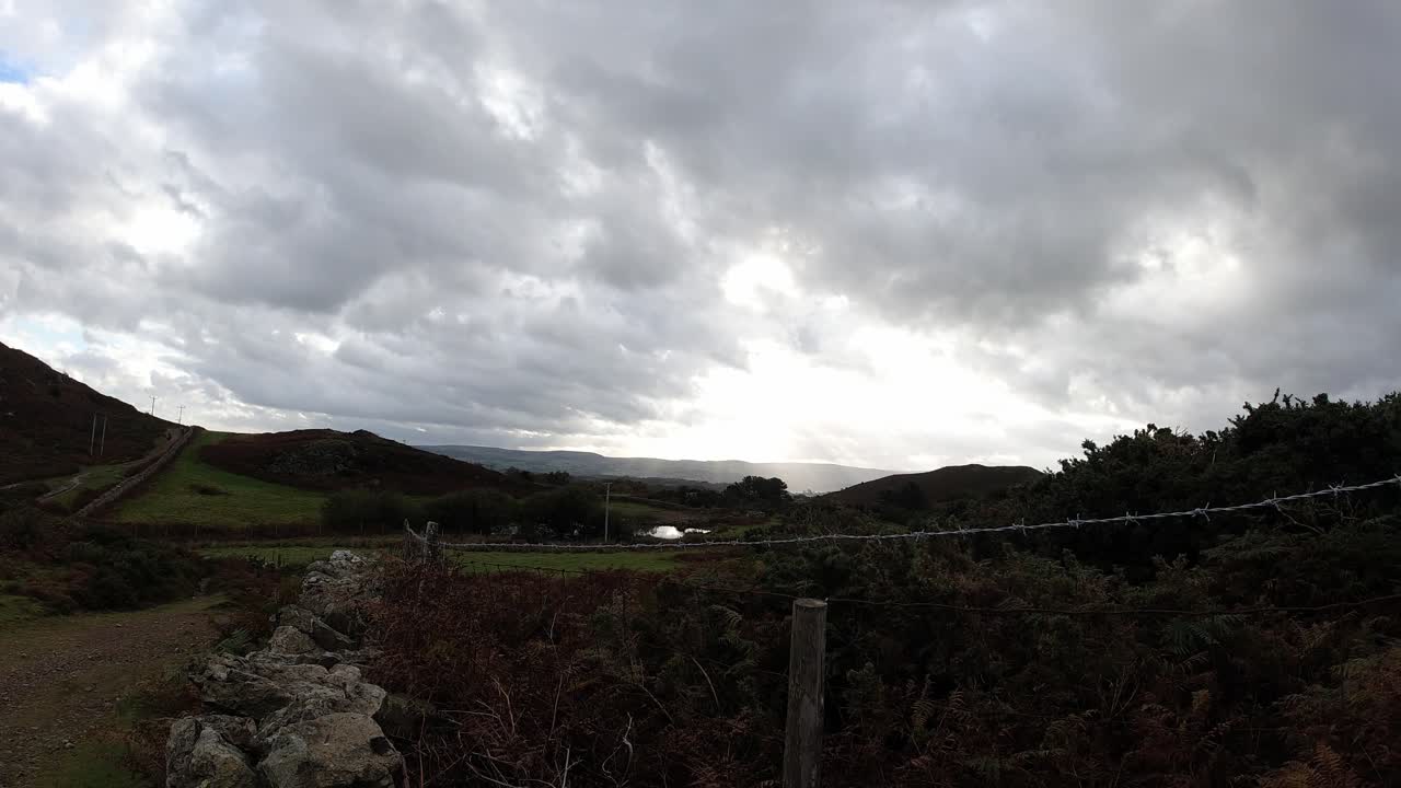 timelapse de los rayos del sol sobre el campo de alambre de púas rural tierras de cultivo paisaje del amanecer temprano