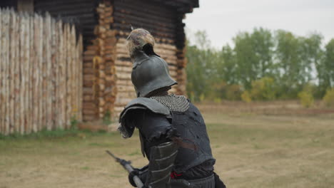 Ritter-Mit-Totenkopf-Auf-Helm-Schwingt-Speer-In-Der-Nähe-Eines-Verbrannten-Hauses