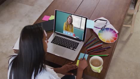 Mujer-Caucásica-Usando-Una-Computadora-Portátil-En-Una-Videollamada-Con-Una-Colega,-Tomando-Notas