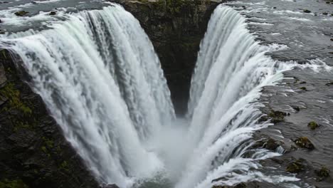 majestic waterfall cascading into a deep chasm, capturing the power and beauty of nature's flowing water in a dynamic landscape scene