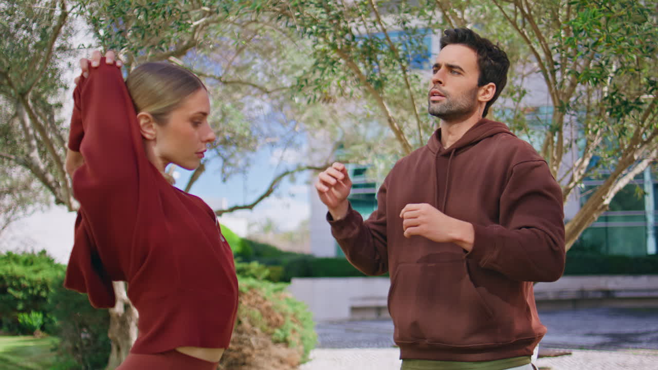 Fitness athlete advice girl on exercise. Active couple training together in city