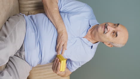 Vertical-video-of-Old-man-waiting-for-someone-with-gift-box.