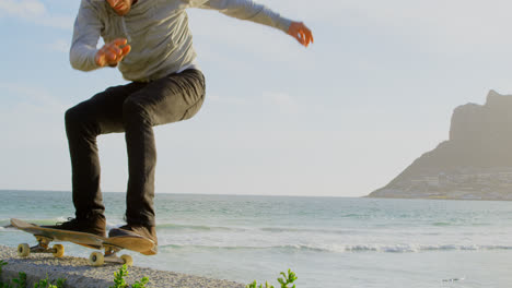 side view of young caucasian man practicing skateboard trick on the pavement at beach 4k