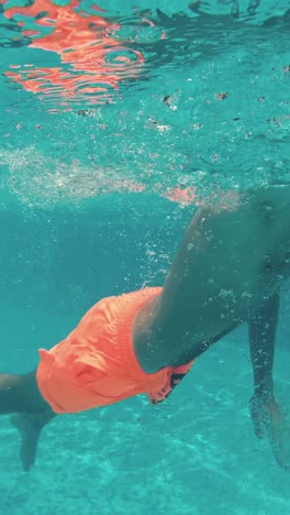 un niño bajo el agua se divierte en la piscina.
