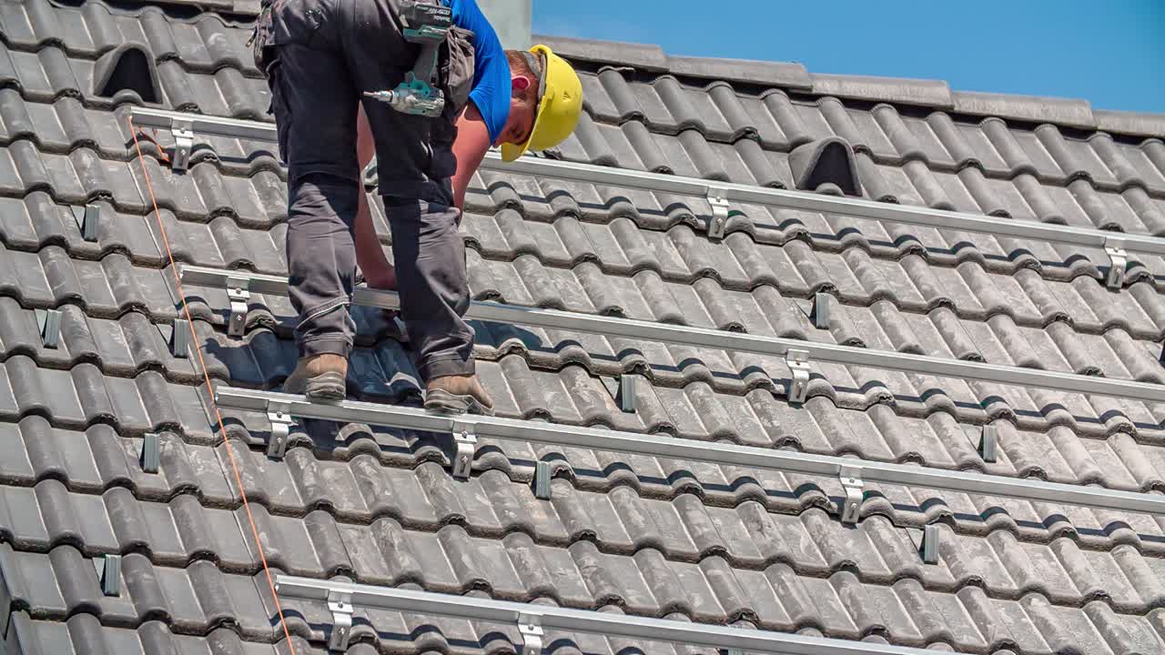 trabajador perforando una base de un solo eje para la instalación de paneles solares en el techo de la casa