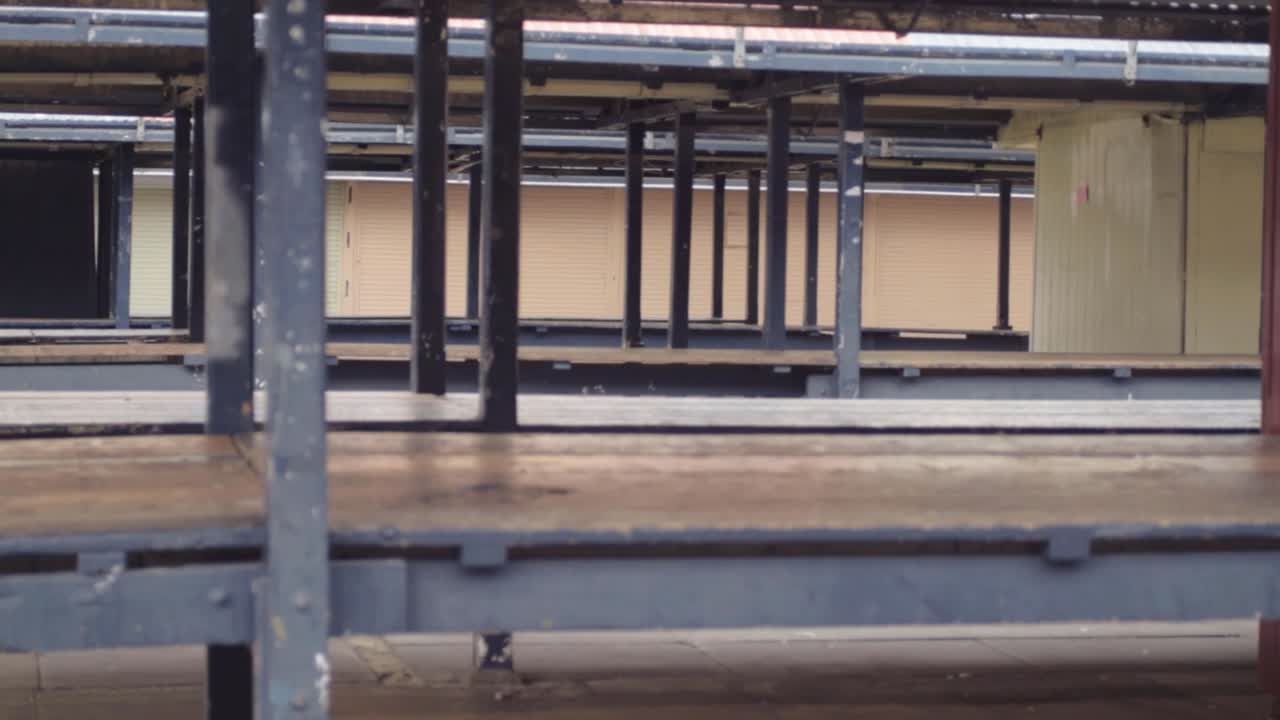 View of rows of empty wooden market stalls