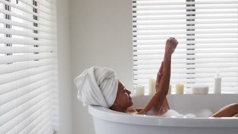 african american woman bathing in the bath tub in the bathroom at home