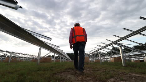 solar panel field being constructed, with construction workers, walking and following shot, low angle