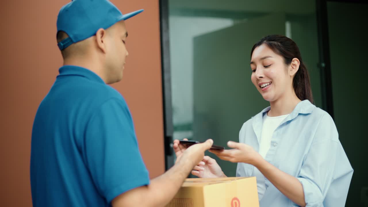 mujer joven firmando firma electrónica en el teléfono inteligente para el acuerdo de contrato digital recibiendo el paquete de un repartidor azul de compras en línea. mensajero hombre entregando el paquete al destino.