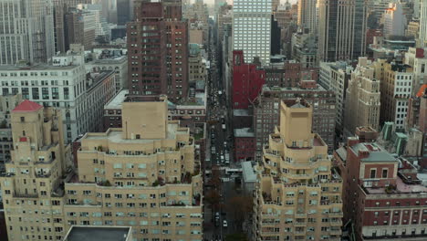 Forwards-fly-above-long-straight-busy-street-surrounded-by-high-rise-buildings-in-city.-Manhattan,-New-York-City,-USA