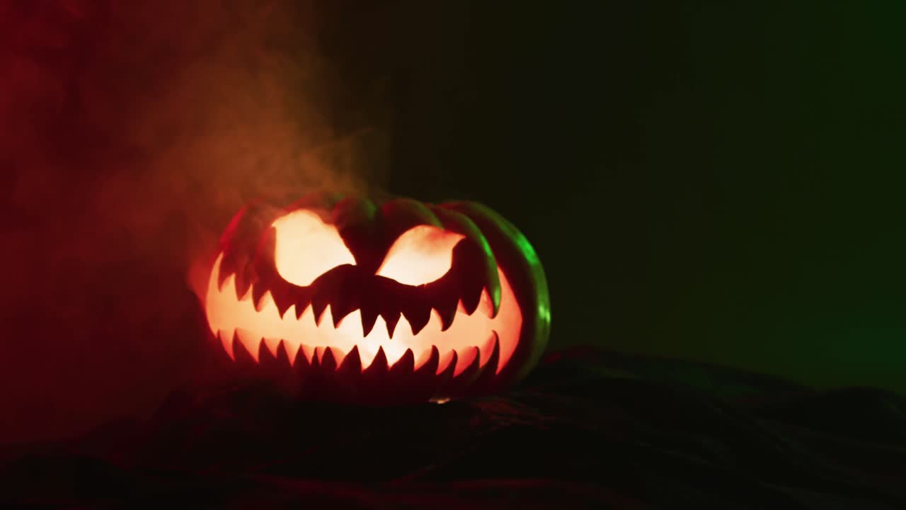 video de calabaza tallada de halloween con humo y luz roja sobre fondo negro
